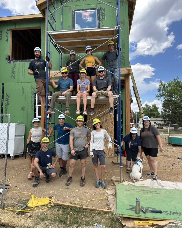 A group of FIRST RF employees on and around scaffolding of a Habitat for Humanity Volunteer Build day.