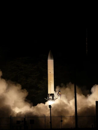A rocket about to take off during the night. Smoke fills the bottom of the photo as the rocket prepares for take-off.