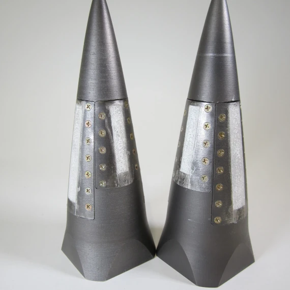 Two side-by-side cone-looking antennas with a white backdrop.