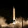 A rocket about to take off during the night. Smoke fills the bottom of the photo as the rocket prepares for take-off.
