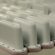A handful of white conformal looking antennas lined up on the production floor.